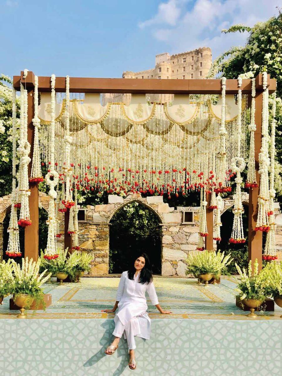 Founder Sujata Bhandari seated beneath a floral Aavaline wedding mandap at a Rajasthan heritage fort