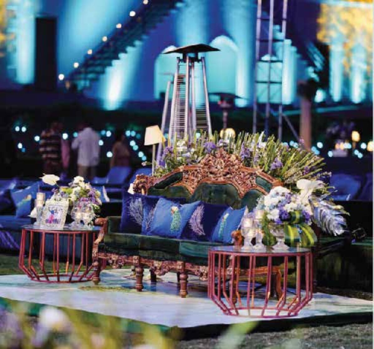An intimate lounge setting lit at midnight, styled with florals and candlelight