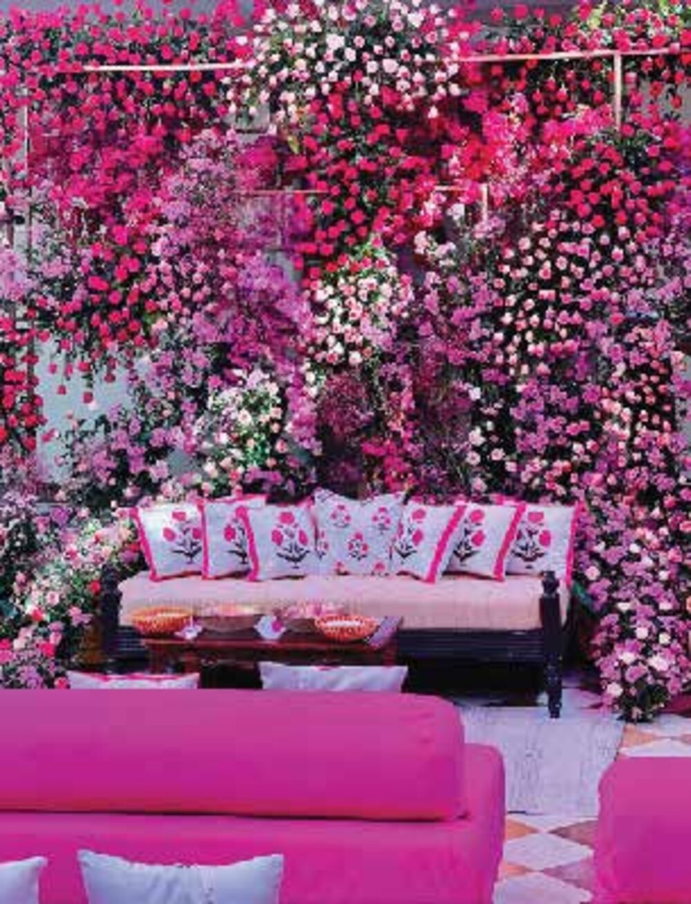 A lounge seating area engulfed in magenta and pink bougainvillea florals